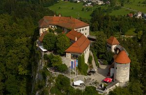 Aerial view of <!--LINK'" 0:106--> showing the layout of castle buildings around the upper and lower courtyards, connected with a staircase. The oldest part of the castle is the Romanesque entrance tower, other sections are Gothic and Renaissance styles.